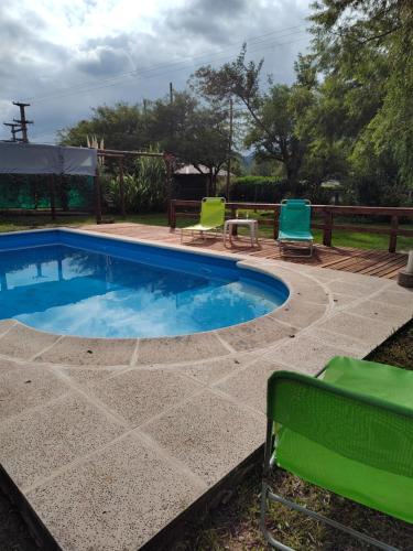 una piscina con 2 sillas de jardín junto a ella en SAN ANTONIO de Arredondo la casa de Andrea en San Antonio de Arredondo