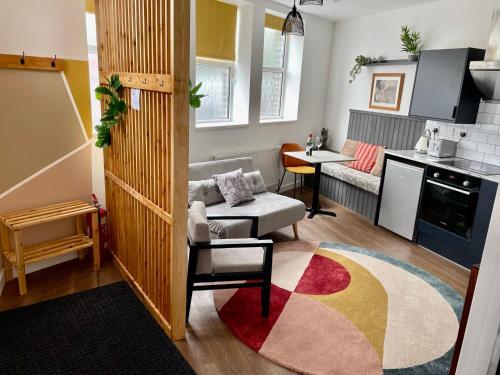 a living room with a couch and a kitchen at The Dance School - 1 and 2 Bedroom Apartments in the Heart of Chesterfield in Chesterfield