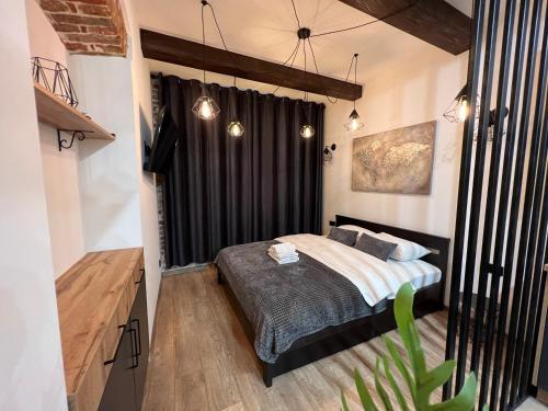 um quarto com uma cama e uma cortina preta em Cozy Loft на Староєврейській 24 em Lviv