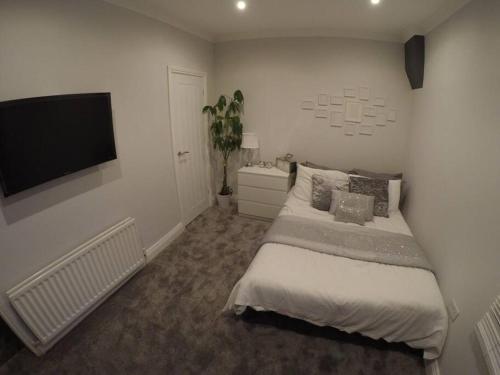 En eller flere senge i et værelse på Essex House 3 Bedrooms Workstays UK