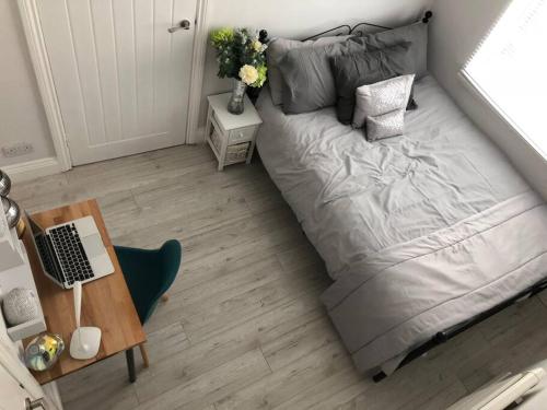 a bed in a room with a desk and a laptop at Falmouth House 3 Bedrooms 5 Beds Workstays UK in Middlesbrough