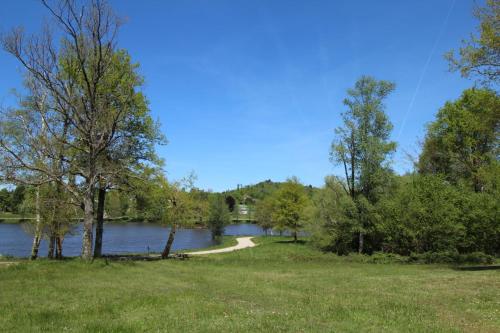a view of a lake with trees and a path at Basse roche in Meuzac