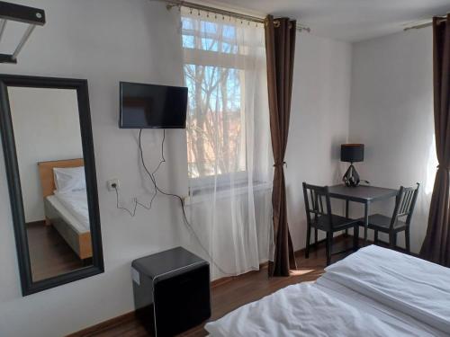 a bedroom with a bed and a mirror and a table at Vila Oltețul in Predeal