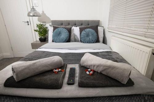 a bed with pillows and a remote control on it at Roscoe House 4 Bedrooms Workstays UK in Middlesbrough