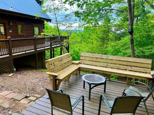 a wooden bench and a table and chairs on a deck at Amazing Views~Secluded Retreat~HotTub~GameRoom in Mineral Bluff
