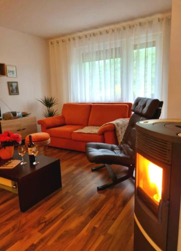 a living room with an orange couch and a fireplace at Apartma Vista montana in Kobarid