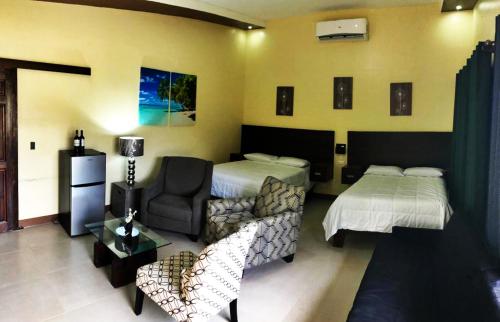 Habitación de hotel con 2 camas y sofá en LOSARA BEACH SALINAS, en El Jobo