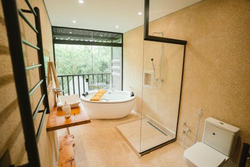 a bathroom with a tub and a toilet and a shower at Reserva Campos do Jordão in Campos do Jordão