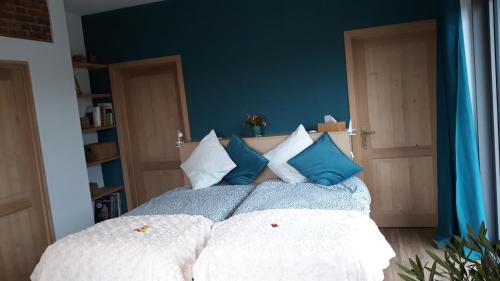 a bedroom with a bed with blue and white pillows at Gite avec piscine La Buissiere - Fernelmont in Pontillas