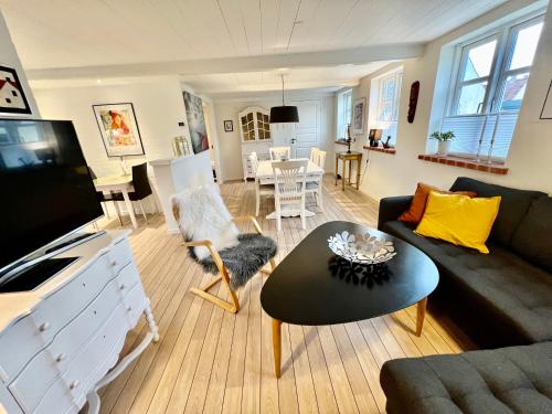 uma sala de estar com um sofá e uma mesa em Lækkert byhus i hjertet af Marstal em Marstal