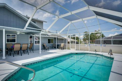 a swimming pool on a patio with a large glass roof at Screened-In Lanai and Yard Port Charlotte Retreat in Port Charlotte