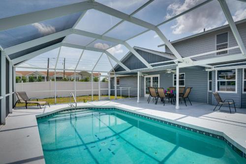 a swimming pool on a patio with a house at Screened-In Lanai and Yard Port Charlotte Retreat in Port Charlotte