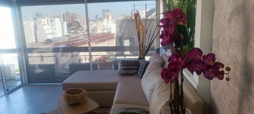 sala de estar con sofá y ventana grande en Apartamento Valentin Gomez en Buenos Aires