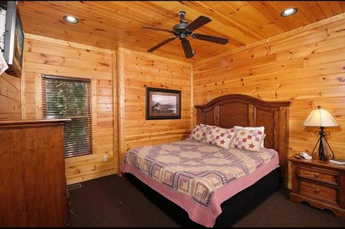 a bedroom with a bed and a ceiling fan at Cabin With Stunning Views, Hot Tub, Game Room in Gatlinburg