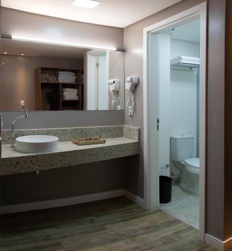 a bathroom with a sink and a mirror at Comfort Hotel Maceió in Maceió
