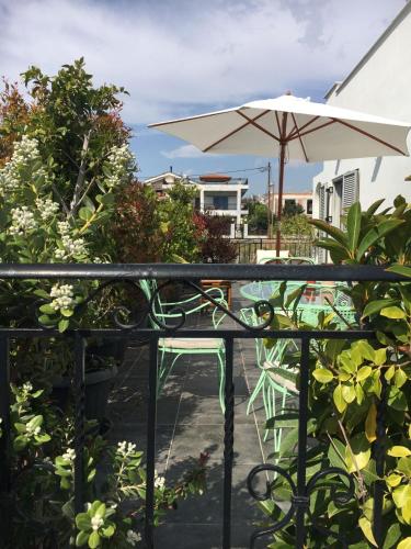 a patio with a table and an umbrella at Sunny Sea House in Rafina