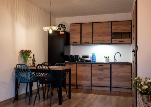 a kitchen with a table and chairs in a room at Karwia Marina Apartamenty in Karwia