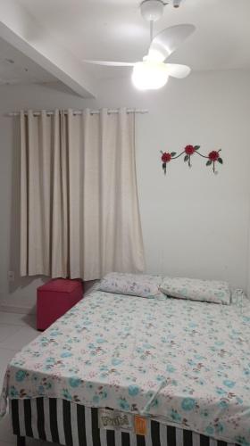 a bedroom with a bed and a ceiling fan at Apartamento aconchegante 2 quartos com suíte na praia de Guaibim in Guaibim