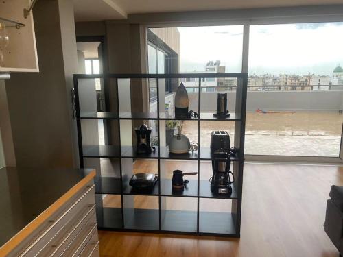 a shelf with various items on it in front of a window at Luxury Loft by Boy in Patra