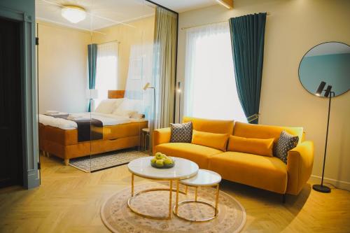 a living room with a yellow couch and a bed at Meerbach Residents in Kuressaare