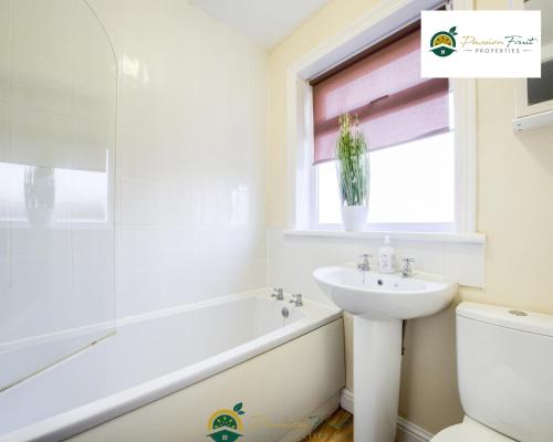 a bathroom with a sink and a tub and a toilet at LOW RATE this season for 5 BR House with 2 Baths- Coventry Near Birmingham By Passionfruit Properties With free Netflix Wi-Fi by A45 - THL in Coventry