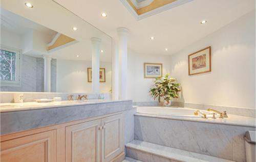 un bagno con una grande vasca e un grande specchio di 5 Bedroom Gorgeous Home In Mandelieu-la-napoule a Mandelieu La Napoule