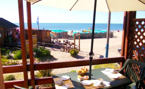 Una mesa en un balcón con vista a la playa. en Hotel Barracuda, en Villa Gesell