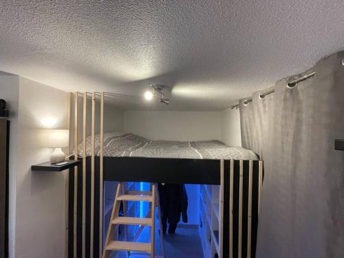 um quarto com uma cama com uma escada em Appartement de 25 m² à Blonville em Blonville-sur-Mer