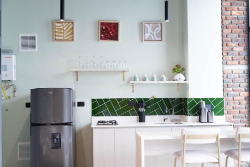 a kitchen with a stainless steel refrigerator and white cabinets at Royal Living Poblado in Medellín