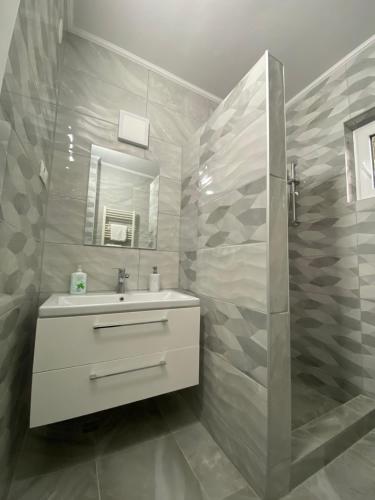 a bathroom with a sink and a shower at Anikó kulcsosház in Corund