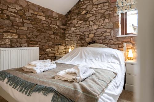 um quarto com uma cama com toalhas em Round Knott, Sebergham, Nr Caldbeck em Sebergham