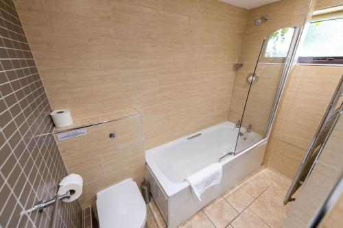 uma casa de banho com uma banheira, um WC e um chuveiro em Round Knott, Sebergham, Nr Caldbeck em Sebergham