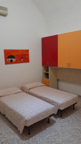 two beds sitting in a room with cabinets at Roslivia in Polignano a Mare