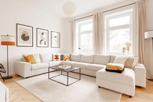 a white living room with a white couch and a table at Villa im Alten Land Hamburg - für große Gruppen in Hamburg
