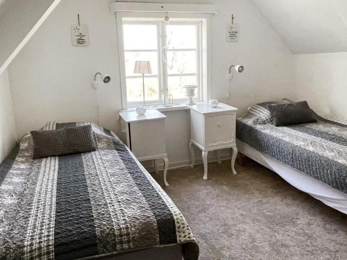 a bedroom with two beds and a window at Holiday home NYHAMNSLÄGE in Nyhamnsläge