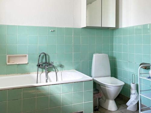 ein Badezimmer mit einer Badewanne, einem WC und einem Waschbecken in der Unterkunft Holiday home NYHAMNSLÄGE in Nyhamnsläge