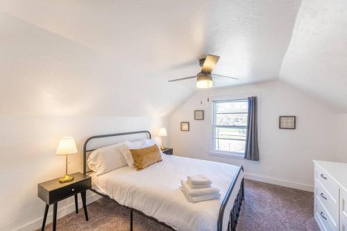 a white bedroom with a bed and a window at Modern, Charming Bungalow by the Park in Saint Paul