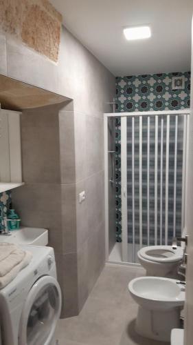 a bathroom with a washing machine and a toilet at Roslivia in Polignano a Mare