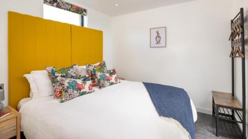 a bedroom with a white bed with a yellow headboard at Ruecroft, Penruddock in Penruddock