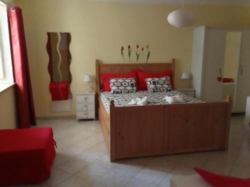ヴェナリア・レアーレにあるSally's Houseのベッドルーム1室(大型木製ベッド1台、赤い枕付)