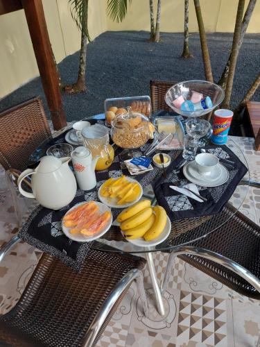 a table with a tray of breakfast food on it at Pousada Ninhal das Garças in Ilha Comprida