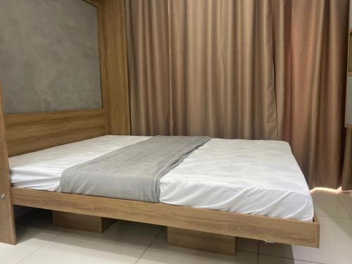 1 cama con marco de madera en una habitación en MAR doce LAR, en Maceió