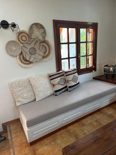 a bench in a room with pillows and a window at Caja De Anthea in Artemida