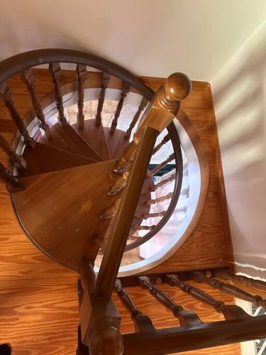 a wooden spiral staircase with a round window at Caja De Anthea in Artemida