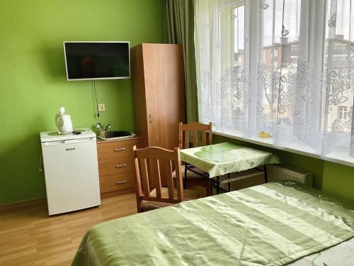 ミエンジズドロイェにあるMiędzyzdrojankaのベッドルーム(ベッド1台、テーブル、テレビ付)