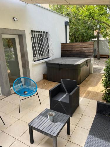 une terrasse avec un bain à remous, une table et des chaises dans l'établissement Jolie Villa avec jacuzzi Hôpitaux facultés, à Montpellier