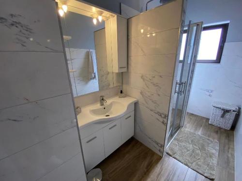 a white bathroom with a sink and a shower at Villa Solis in Split