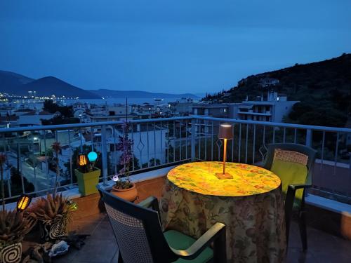 a table with a lamp on top of a balcony at Maria GuestHouse in Aliveri