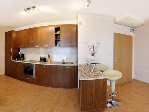 a kitchen with wooden cabinets and a counter top at Sea Dream Rental Apartments in Varna City