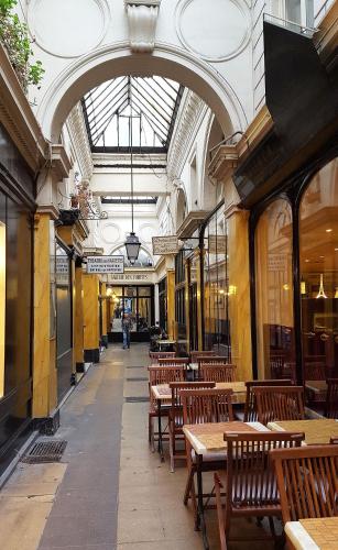 un restaurant avec des tables et des chaises en bois dans un bâtiment dans l'établissement Sophisticated Gem in the Heart of Paris - 107m2, à Paris